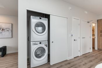 A white washing machine and dryer in a modern laundry room.